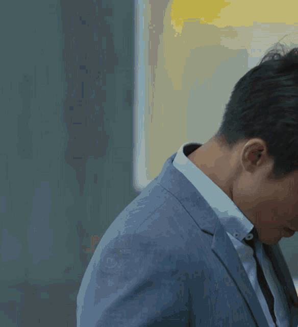 a man in a suit and tie is looking down with the number 5 on his back