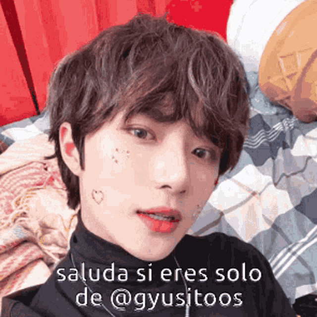 a close up of a person 's face with the words saluda si eres solo de @gyusitoos on it .