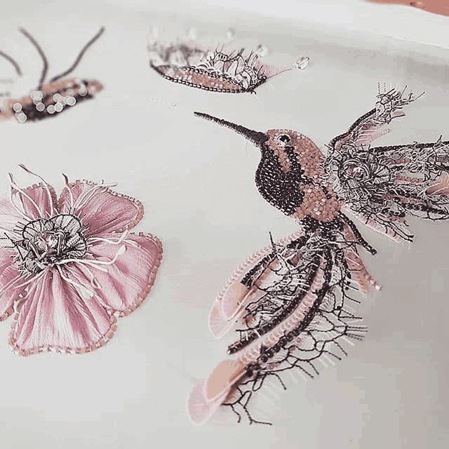 a drawing of a hummingbird with a pink flower behind it