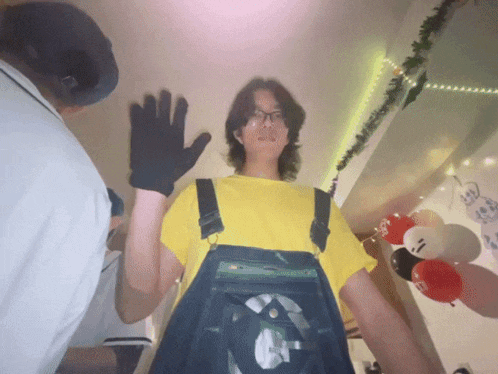 a person wearing overalls and a yellow shirt with a smiley face on it