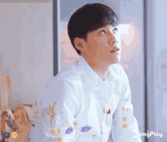 a man wearing a white shirt with flowers on it