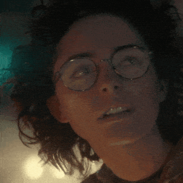 a close up of a person wearing glasses with a surprised look on their face