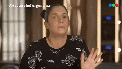 a woman wearing a black shirt with dragons on it is on a television show called masterchef argentina