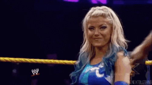 a woman with blue hair is standing in a wrestling ring with a rope around her waist .