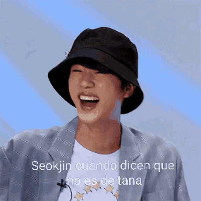 seokjin cuando dicen que no es de lana is written on a picture of a man wearing a hat