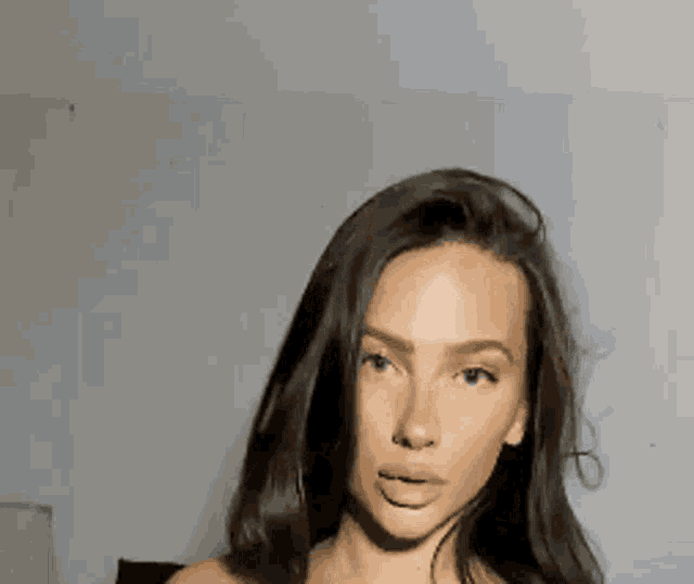a close up of a woman 's face with long dark hair