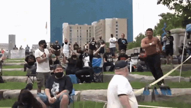 a man is standing on a rope while a crowd watches .