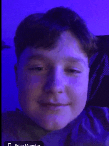 a close up of a young boy 's face with a blue background