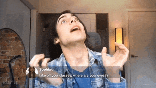 a man in a plaid shirt is asking sophia to take off her glasses