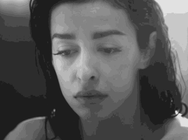 a black and white photo of a woman 's face looking down .