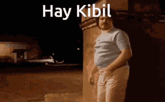 a man leaning against a wall with the words hay kibil on the bottom