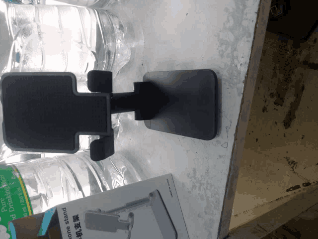 a phone stand is sitting next to a bottle of water