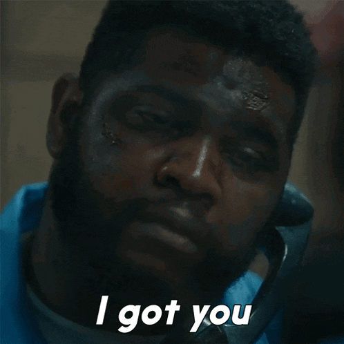 a man with a beard is talking on a phone and says " i got you " in white letters