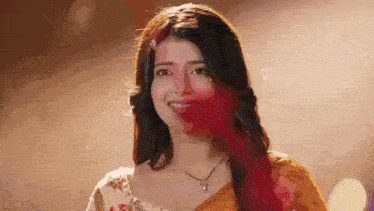 a close up of a woman 's face with red paint on it .
