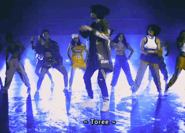 a group of people are dancing and the word toree is on the screen