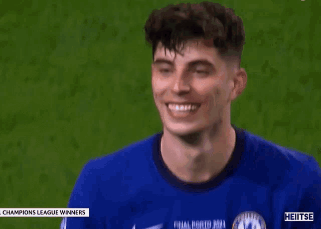 a soccer player wearing a blue jersey is giving a thumbs up .