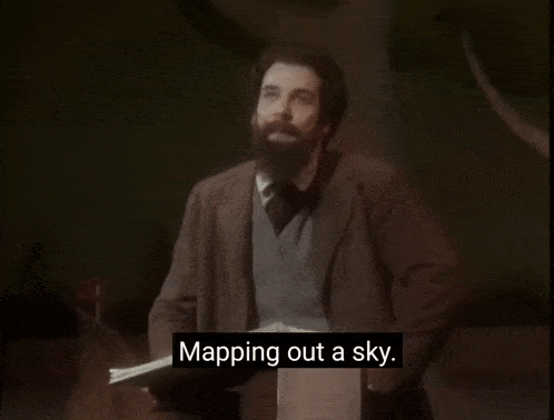 a man with a beard stands in front of a piano and says what you feel like planning a sky