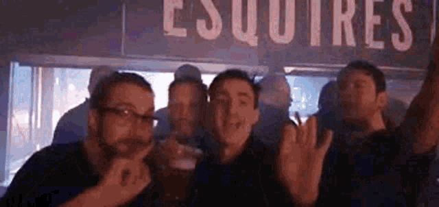 a group of men are standing in front of a sign that says esquire .