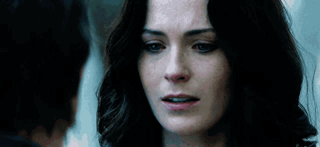a close up of a woman 's face with a tear running down her face .