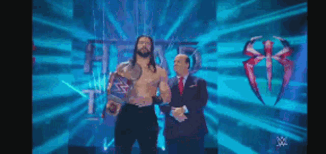 a man in a suit and tie is standing next to another man in a suit and tie on a stage .