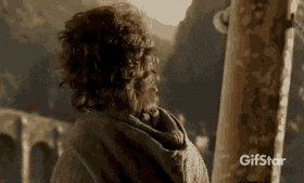 a man with curly hair is standing in front of a mountain and a sign that says gifstar on it