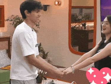 a man and a woman are holding hands in a room