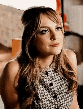 a close up of a woman wearing a black and white dress and a necklace .