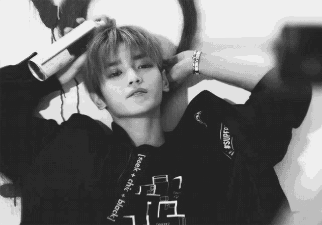a black and white photo of a young man wearing a sweatshirt that says ' feel chic + black '
