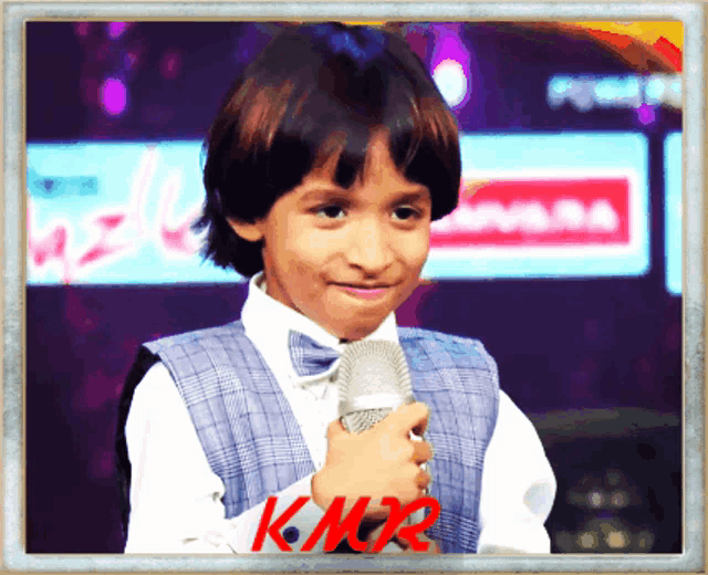 a picture of a young boy holding a microphone with kmtr written in red
