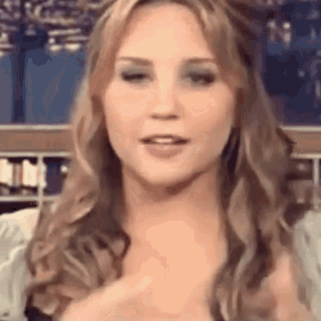 a close up of a woman 's face with long blonde hair making a funny face .