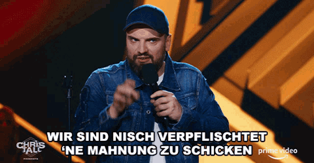 a man in a denim jacket stands in front of a microphone and says wir sind nisch verflischt ne mahnung zu schicken
