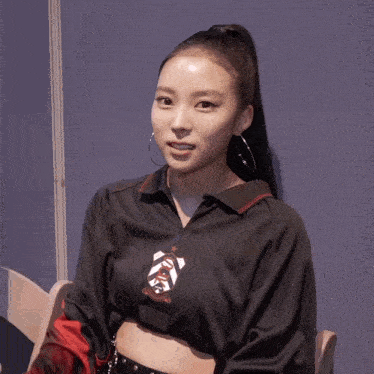 a woman with a ponytail wearing a black shirt that says ' a ' on it