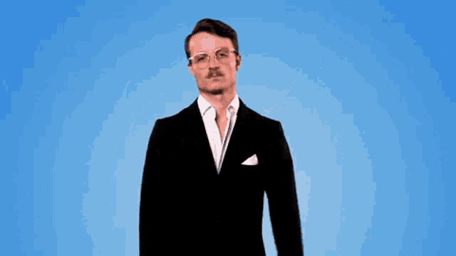 a man in a suit is dancing in front of a blue background