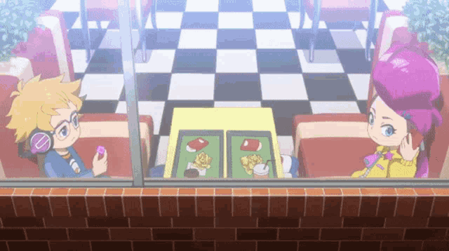 a boy and a girl are sitting at a table with food