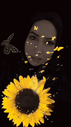a woman in a black hijab is holding a sunflower with butterflies flying around her face