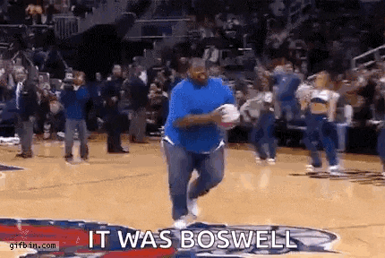 a man in a blue shirt is running on a basketball court while holding a basketball .