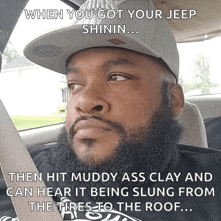 a man with a beard wearing a hat is sitting in a car .