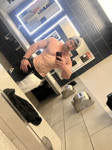 a man taking a picture of himself in a bathroom mirror