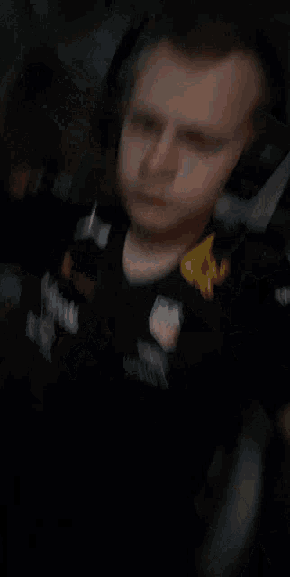 a man wearing headphones and a red bull shirt is making a funny face .