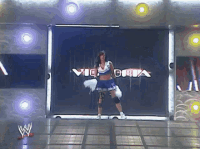 a cheerleader is dancing in front of a victoria sign