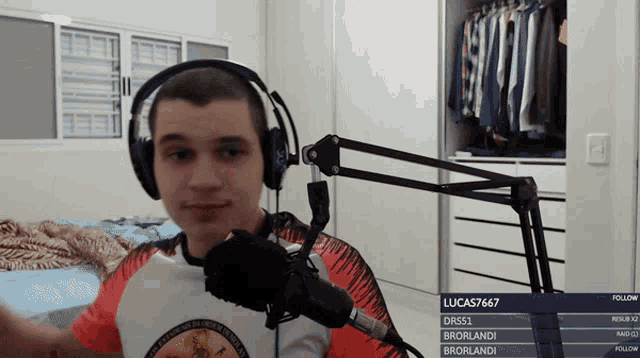 a man wearing headphones stands in front of a microphone with the username lucas767