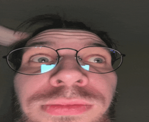 a close up of a man 's face with glasses