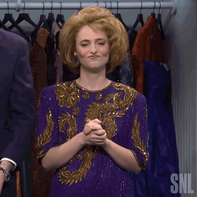 a woman in a purple and gold dress is standing in front of a closet with snl written on it