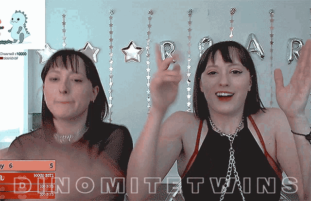 two women are dancing in front of a sign that says " dnomitztwins "