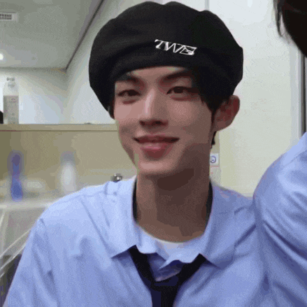 a young man wearing a beret and a tie is smiling .