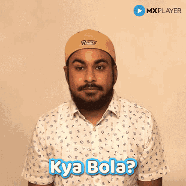 a man wearing a rams hat and a shirt says kya bola