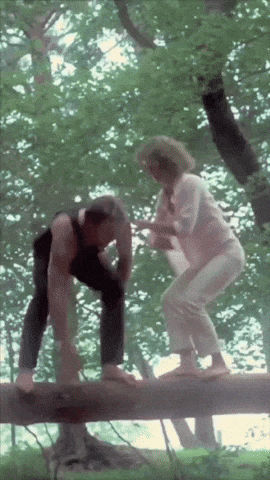 a man and a woman are balancing on a log