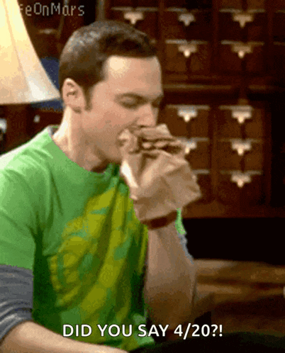a man in a green shirt is eating a sandwich and says did you say 4/2