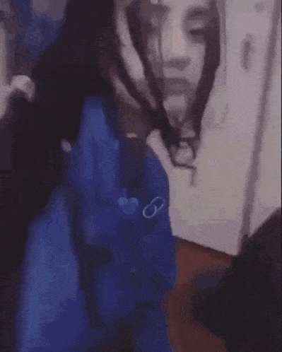 a blurry picture of a person wearing a blue shirt and sunglasses .