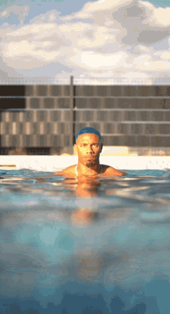 a man swimming in a pool with a blue headband on